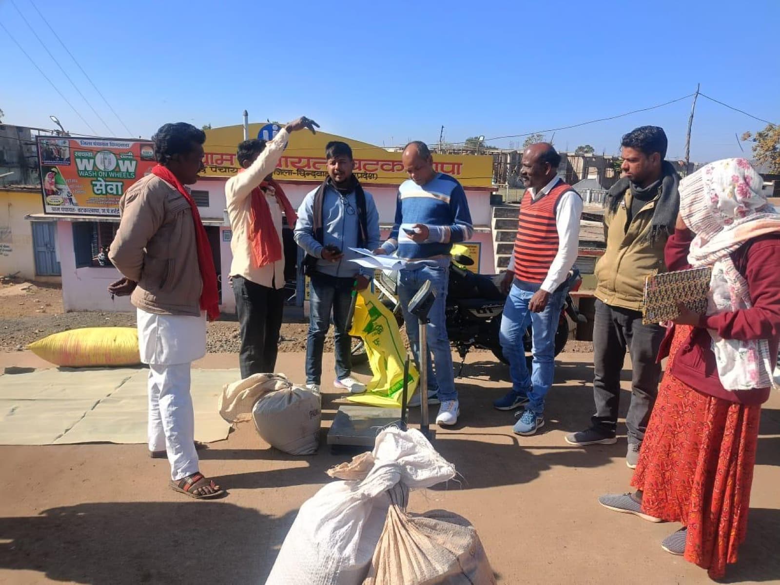 Farmers weighing millet at a block-level procurement centre